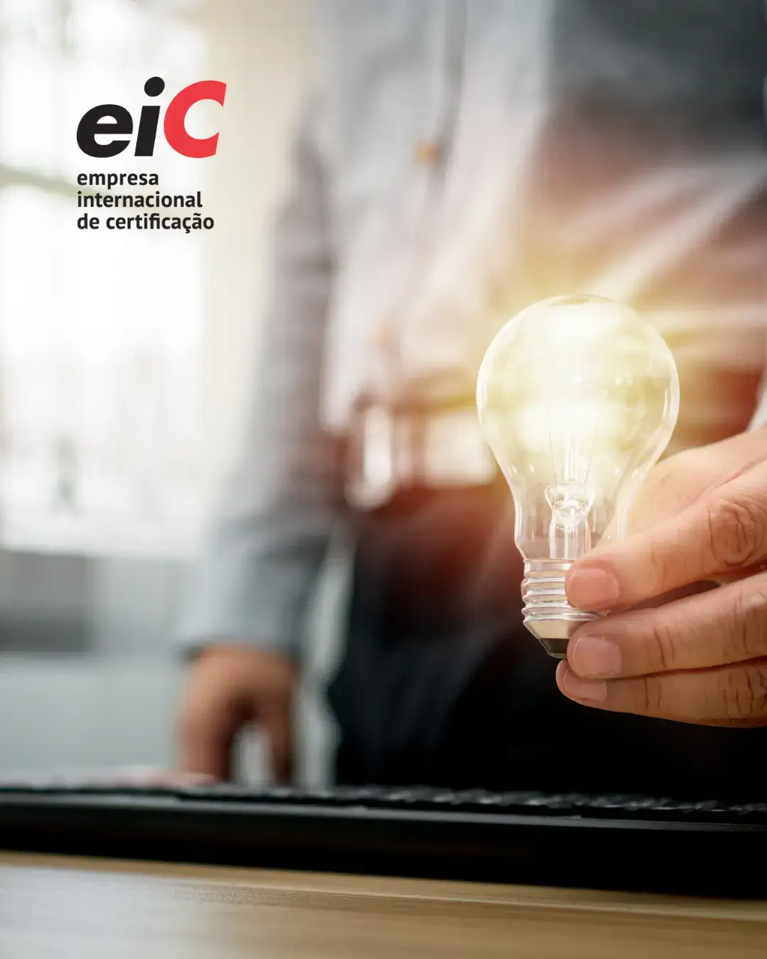 Mão a segurar lâmpada luminosa com logótipo EIC