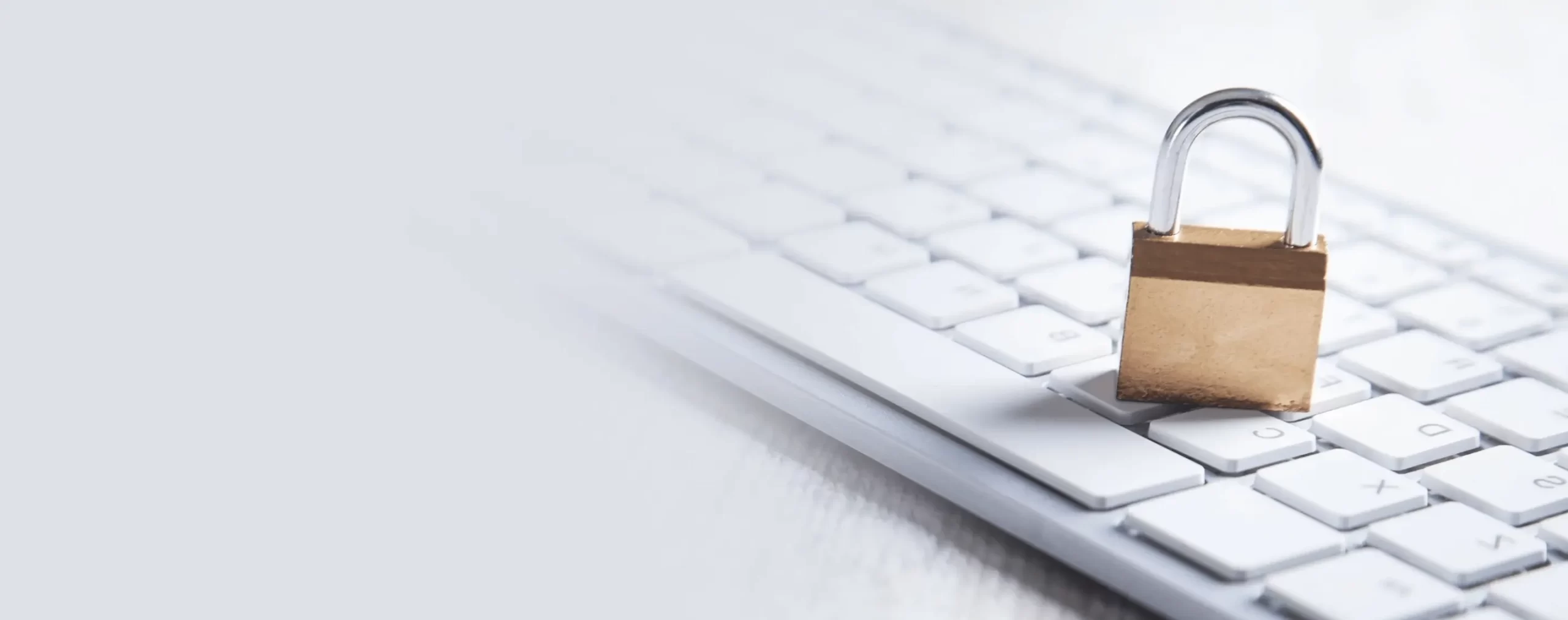 Cadeado dourado sobre teclado de computador branco