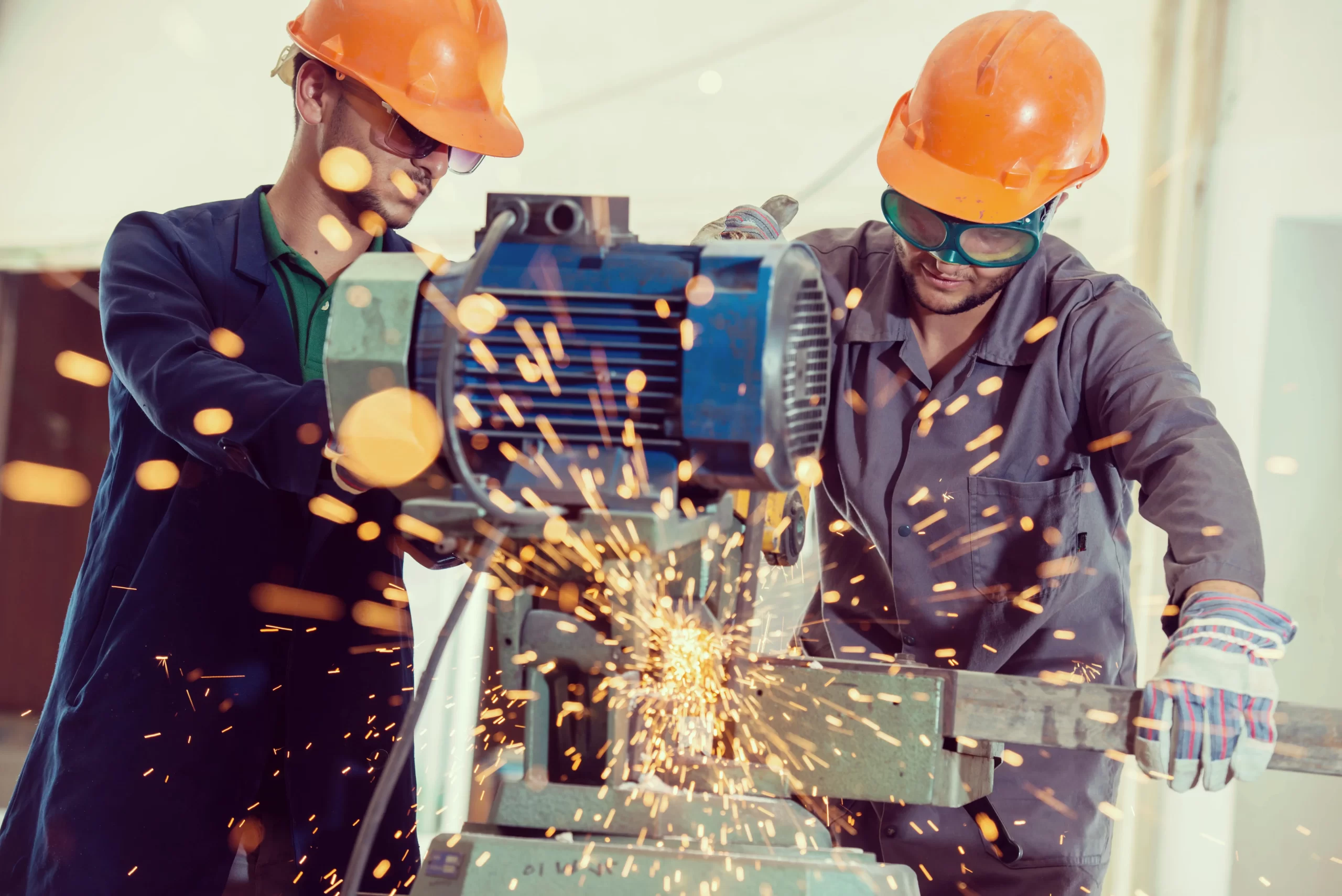 shutterstock_261044822-min Dois trabalhadores de capacete a operar uma máquina de corte
